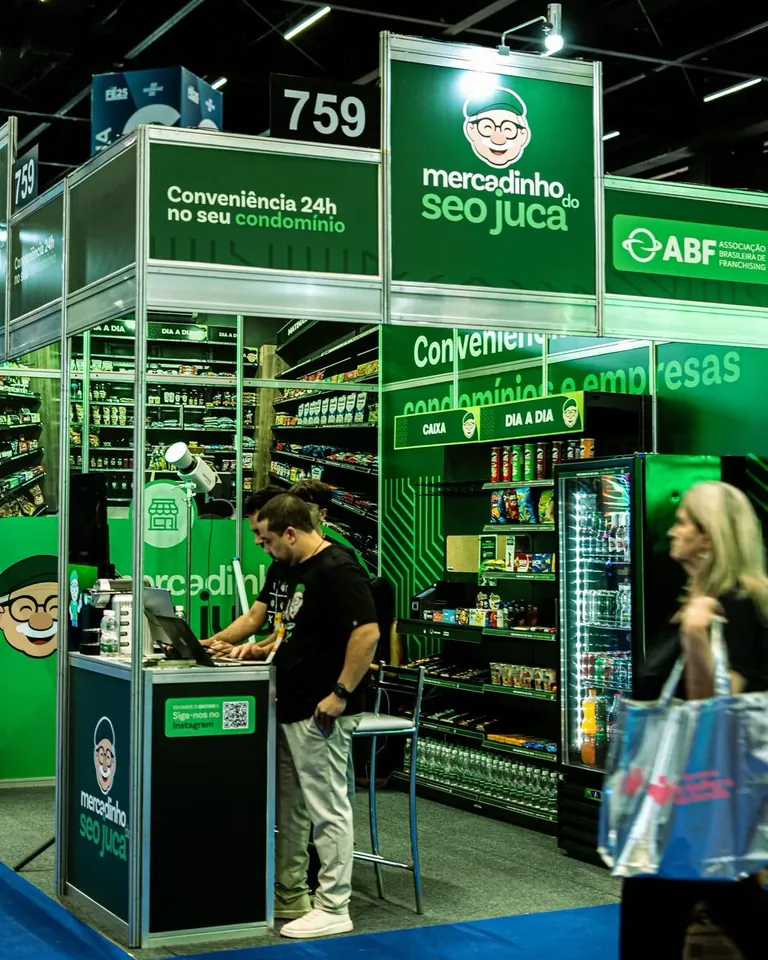 Estande do Seo Juca na Feira do Empreendedor 2025, com geladeiras e totem expostos