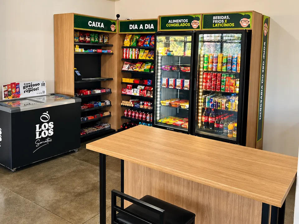 Loja do Seo Juca em uma empresa, com caixa, prateleiras e geladeiras abastecidas